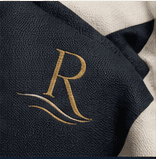 Close-up of a refined Riviera monogram on dark fabric